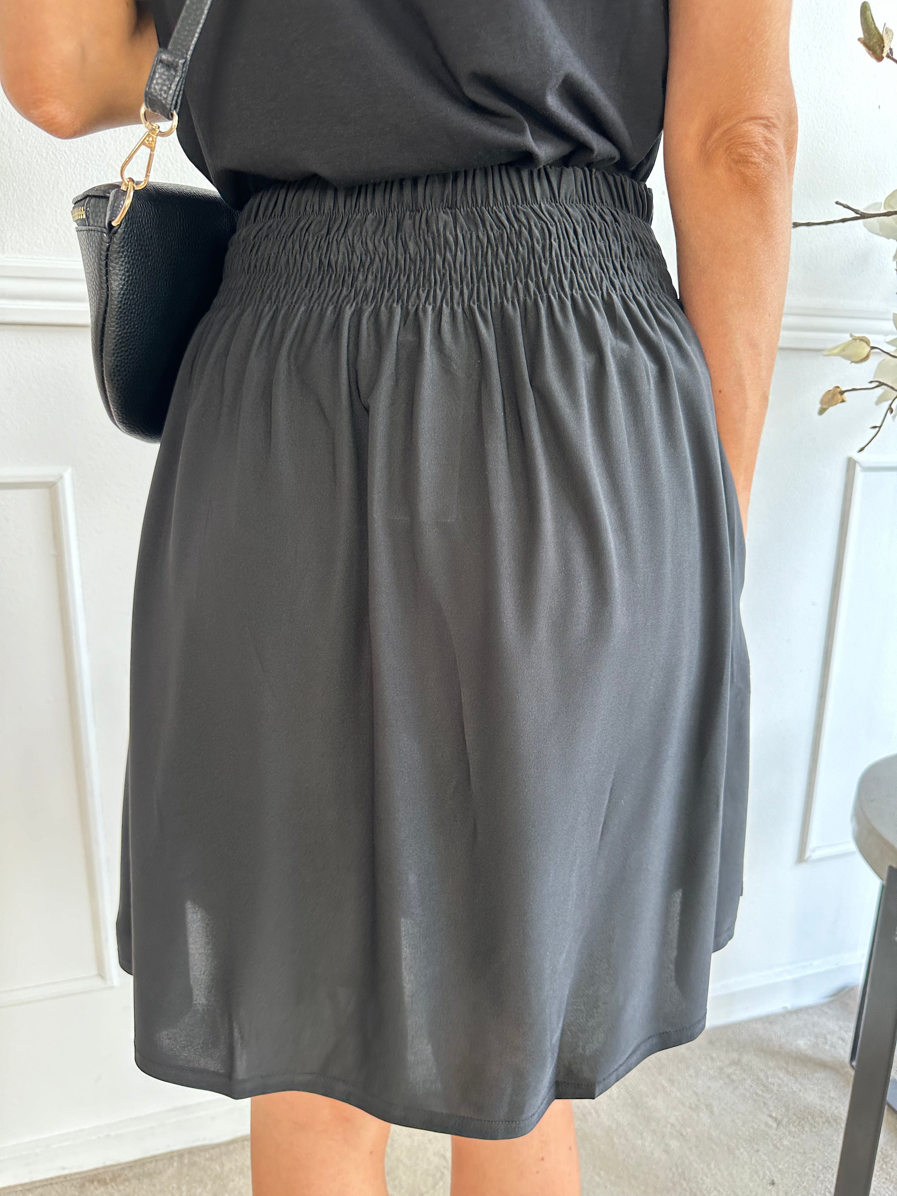 Pams Plain Short Skirt - Kort kjol i stretchigt tyg med fickor